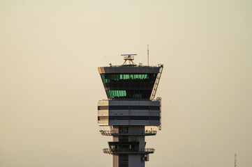 The distinctive control tower of Brussels Airport stands tall in warm evening light in Belgium, the hub of air traffic control at the airport. © Oksana