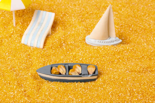 Miniature Summer Beach Vacation Scene with Toy Boats and Accessories on Golden Sand