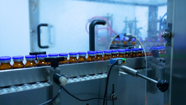 vials factory of injections. powder medical drug filling glass vials rotating for packaging in an injection production line in a pharmaceutical manufacturing company medicine making process