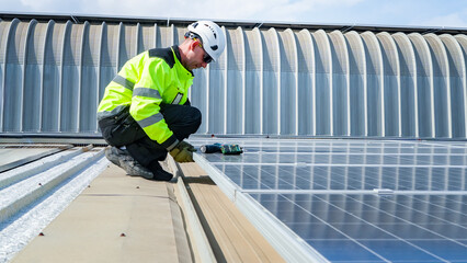 Worker installs solar panels on a rooftop during daylight hours at a commercial building © FotoArtist