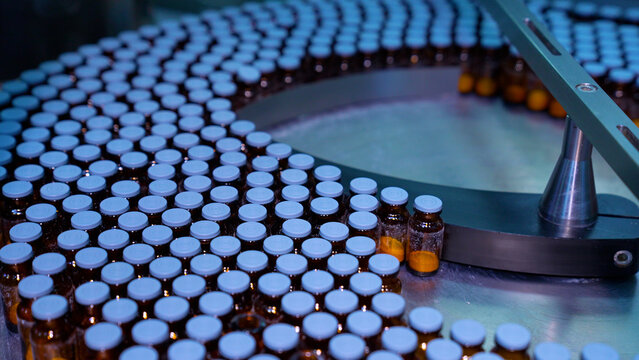 vials factory of dry powder injections. powder medical drug filling glass vials rotating for packaging in an injection production line in a pharmaceutical manufacturing company medicine making process