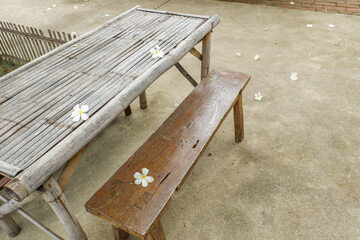 Wooden table and chair and frangipani flowers in restaurant, outdoor cafe scandinavian style,Rattan detailed craftsmanship and pattern,summer beach concept. © wanatithan