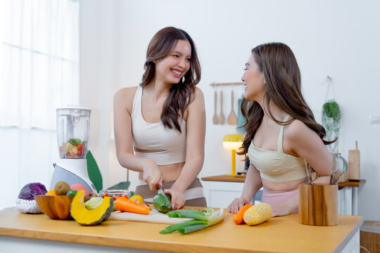 Young women making a nutritious smoothie with fresh ingredients at home representing clean eating healthy habits friendship and everyday wellness
