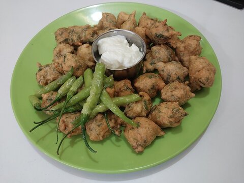 Top View of Crispy Indian Pakora Served with Curd and Green Chilies