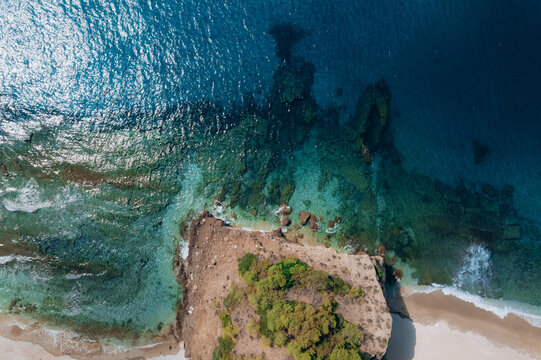 Aerial drone of a peaceful beach in Thassos, Greece, featuring transparent turquoise water, paddleboards, swimmers and a beautiful Mediterranean coastline.