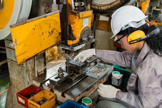 Close-Up Of Gloved Hands Placing Metal Part Into Power Press Die
