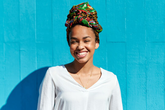 Young woman smiling confidently wearing a colorful headscarf