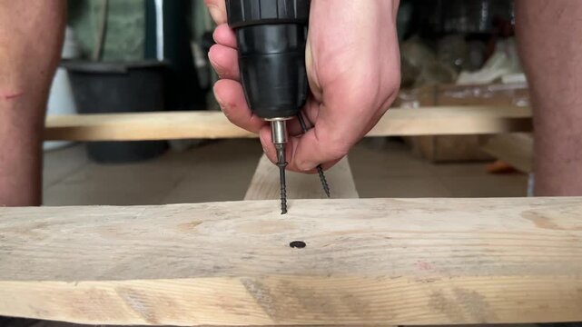driving a screw into a board with a power screwdriver . High quality 4k footage