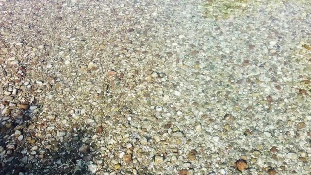 Crystal clear river flowing through the mountains. Mountain river with visible pebbles under clear water. Transparent river stream.