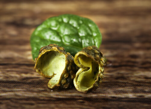 Fresh Garcinia Cambogia Fruit Halves - High Quality Aromatic Asian Cooking Ingredient on Wood Background