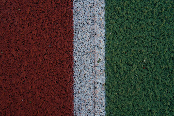 Fototapeta premium rubber surface of sports grounds, green white and red colors with structure and texture