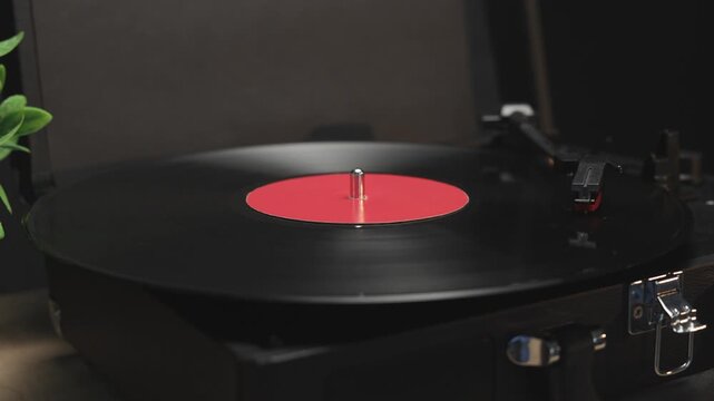 Vintage record player spins a vinyl disc with a red label