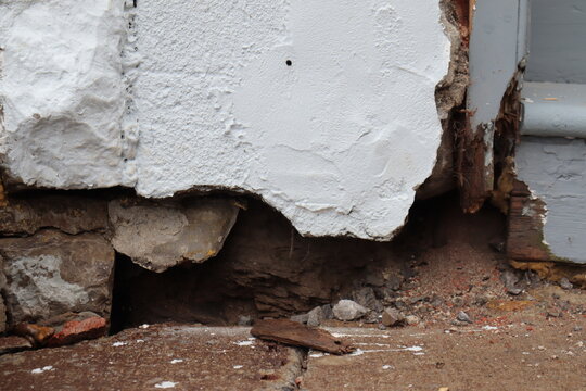 Outdoor old brick wall background. Old house problem and hole in the facade. House renovation and foundation crack. Construction industry and outdoor renovation for old house.