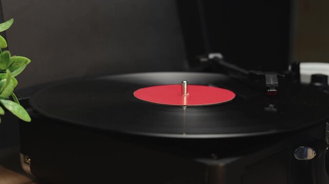 Vintage record player spinning a black vinyl disc with a red label