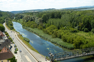 Obraz premium Beautiful top view of a European river bend, green lush forest and a road with cars