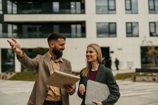 Real estate agent showing property to client outdoors