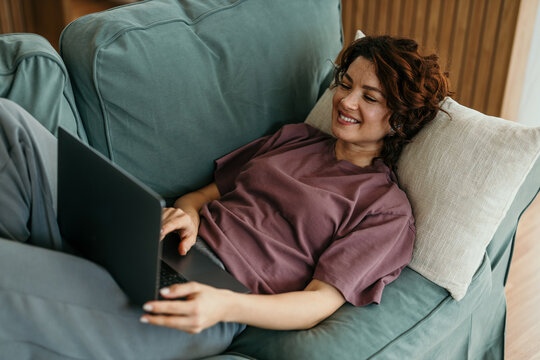 Woman relaxing at home using laptop computer