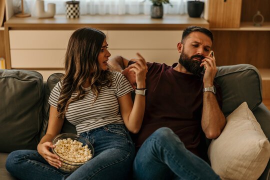 Couple having conflict ignoring partner during phone call