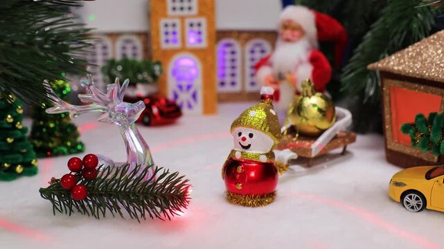A little snowman in the center of a small Christmas town