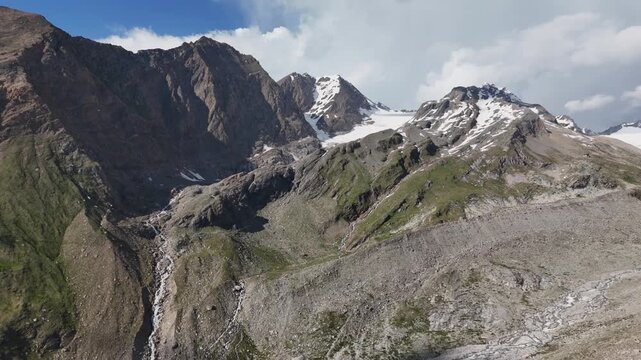 ⁠Wide aerial drone shot of a massive rocky mountain wall and steep alpine terrain near Hochfeiler in the Zillertal Alps.⁠