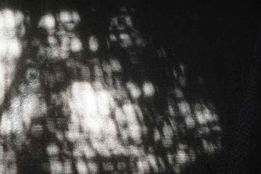 Abstraktes Licht- und Schatten Motiv mit schwarz-wei&szlig;em Maschenmuster als Hintergrund