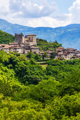 Obraz premium Tenno Castle standing on a rocky spur with its small medieval village at its foot in spring, Trentino