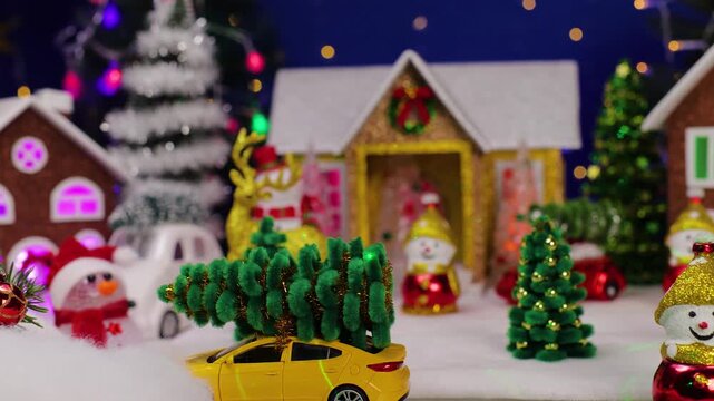 A Christmas town with a yellow car and a snowman in the foreground
