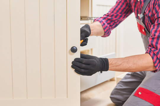 Woodworking professional fastening door hinge screws, precise carpentry skills during home improvement project
