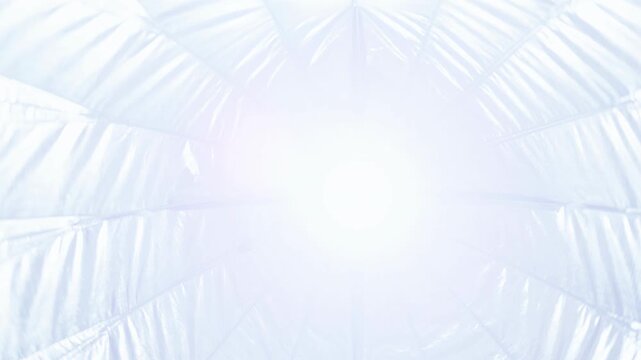 Parabolic softbox interior with silver reflective fabric in photography studio.