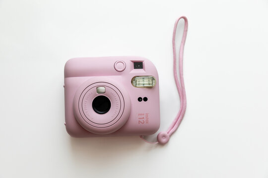 Moscow, Russia - 10.06.2025: The pink Fujifilm Instax mini 12 instant camera over white background. Photography enthusiasts, capturing memories, and creative projects