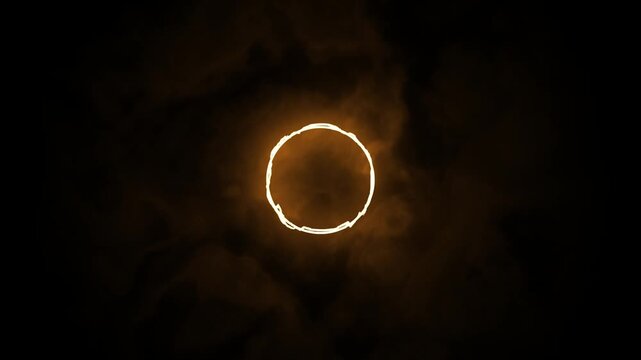 Glowing golden ring floating in dark abstract smoke
