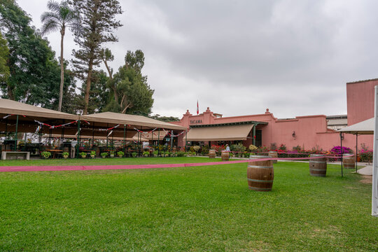 Ica, Peru, July 04, 2026: Exterior of Tacama wine tourism destination in Ica, Peru, featuring traditional architecture, gardens, outdoor seating and decorative barrels.