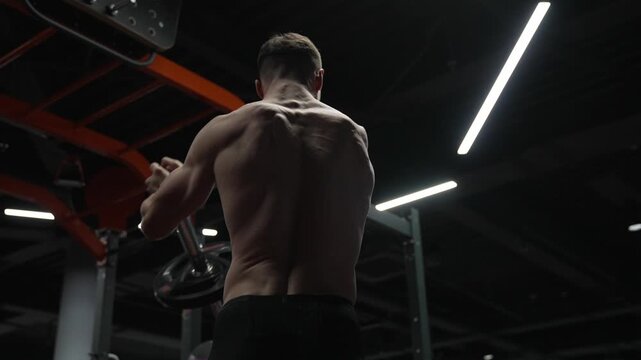 Athletic man performing landmine exercises with barbell. Strength and fitness. Muscular sportsman in sport gym do landmine exercise. Sport sportsman with barbell landmine in gym. Slow motion