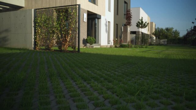 Sunlight casting shadows on modern townhouses with eco-friendly permeable paving 
