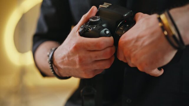 Close up photographer hands adjusting settings dial DSLR camera studio