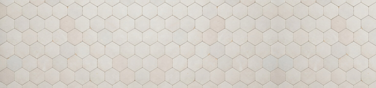 Panoramic view of off white ceramic hexagon tiles arranged in a repetitive geometric pattern