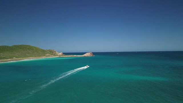 Aerial drone shot of a traditional local panga boat speeding through the beautiful waves and stunning turquoise waters of Cabo Pulmo, coastal tourism and travel
