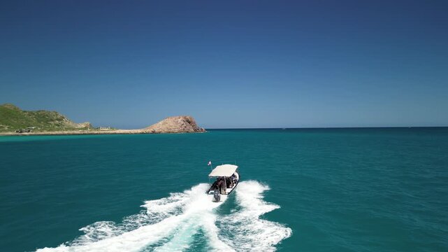 Aerial drone shot of a traditional local panga boat speeding through the beautiful waves and stunning turquoise waters of Cabo Pulmo, coastal tourism and travel
