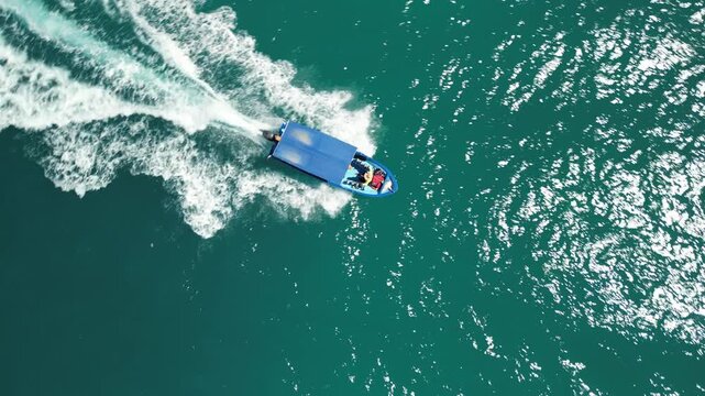 Aerial drone shot of a traditional local panga boat speeding through the beautiful waves and stunning turquoise waters of Cabo Pulmo, coastal tourism and travel
