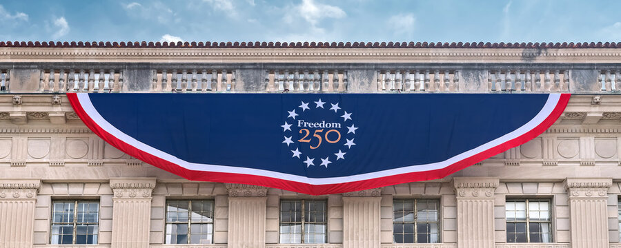 Freedom 250 patriotic banner spans the Department of Commerce facade in Washington.
