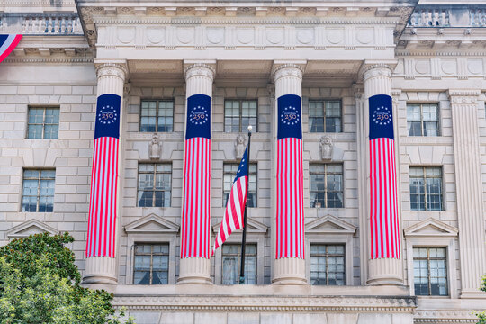Decorated columns frame an American flag on the Washington Commerce building facade.