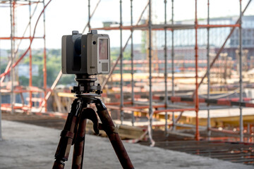Surveying equipment stands on a tripod at a construction site © I