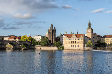 Fototapeta premium Vltava River in Prague featuring Charles Bridge, the Old Town Bridge Tower, and the Smetana Museum water tower. The historic architecture