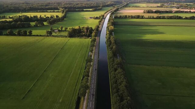 Aerial view of a canal cutting through a lush, green countryside landscape.