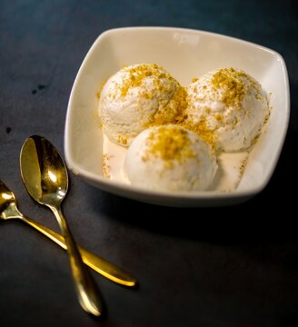 Bowl with tasty vanilla ice cream on a dark background