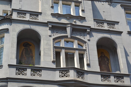 Detailed Prague facade with arched niches and painted fresco panels for architectural background and restoration design reference
