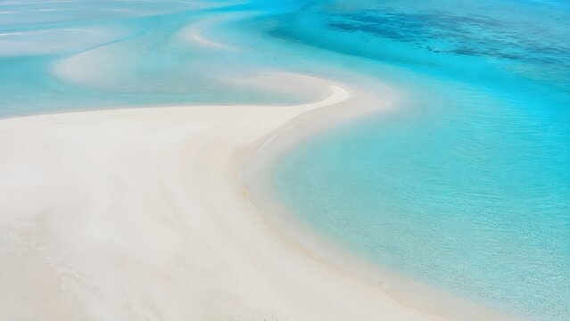 Abstract aerial view of sandbanks and turquoise ocean water patterns.