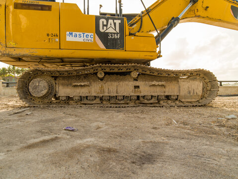 Side profile of a yellow Caterpillar CAT 336F excavator with MasTec Civil logo on a sandy construction site in the USA, Hollywood, Florida - April 05, 2026.