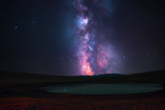 Milky Way  galaxy on the sky over the lake and mountains Space, night scene time lapse.