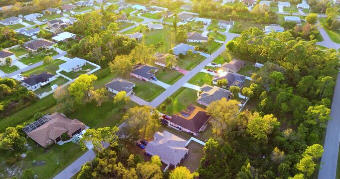 High angle view of North Port residential community at sunset with private homes, green yards and organized streets, capturing suburban sprawl, wealth, and housing market growth in the USA.